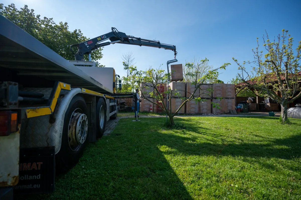 Nákladné vozidlo s mechanickou rukou pripravené na prepravu tovaru